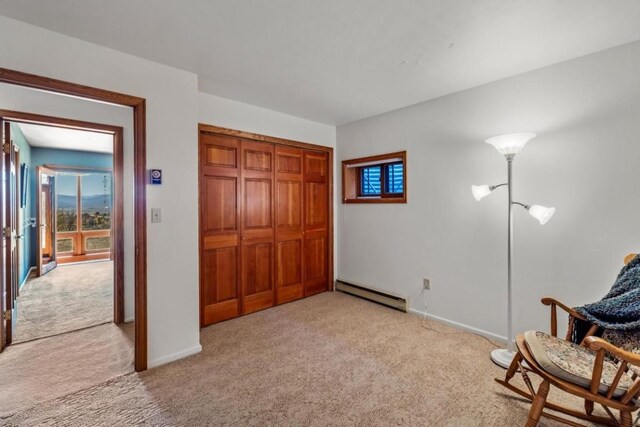 living area featuring light colored carpet and baseboard heating