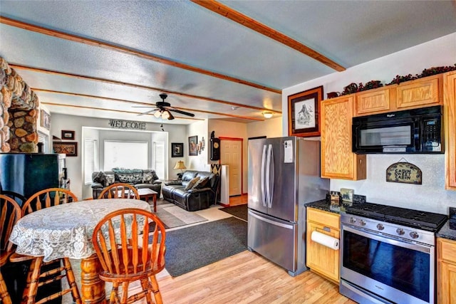 kitchen with a textured ceiling, ceiling fan, stainless steel appliances, and light hardwood / wood-style flooring