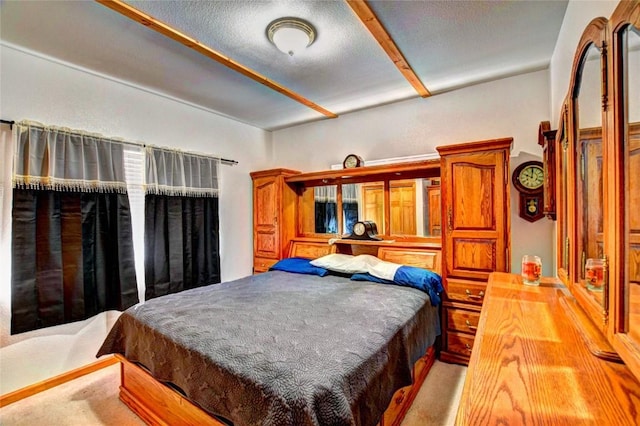 bedroom with a textured ceiling and light colored carpet