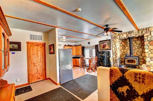 living room with light colored carpet, a wood stove, and ceiling fan