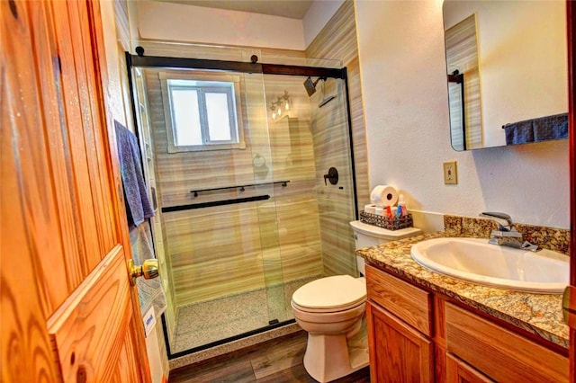 bathroom with vanity, hardwood / wood-style flooring, toilet, and an enclosed shower