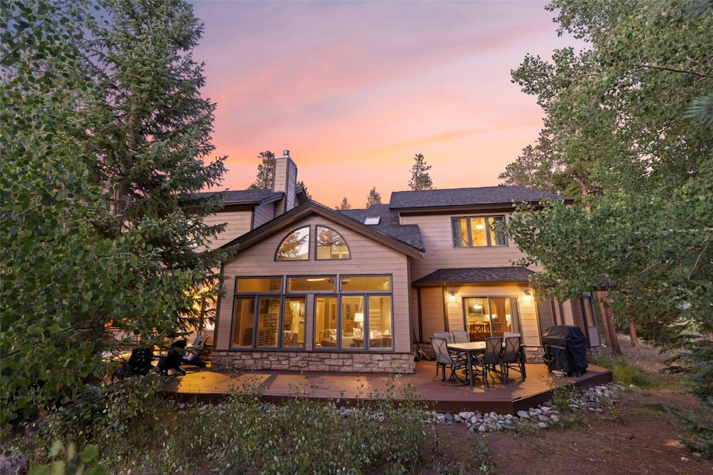 back house at dusk with a deck