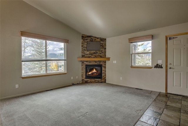 unfurnished living room with a fireplace, carpet flooring, and lofted ceiling