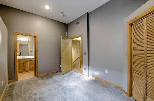 unfurnished bedroom featuring connected bathroom, light colored carpet, and a closet