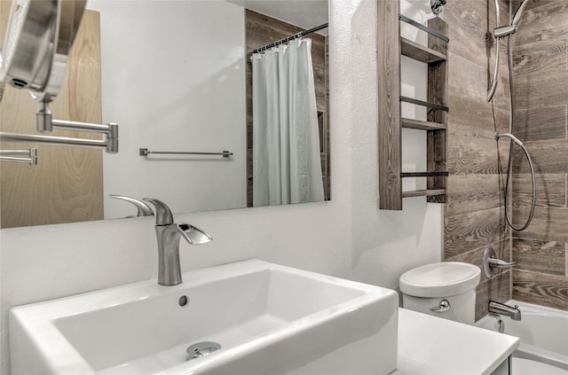 full bathroom featuring sink, shower / bath combination with curtain, and toilet