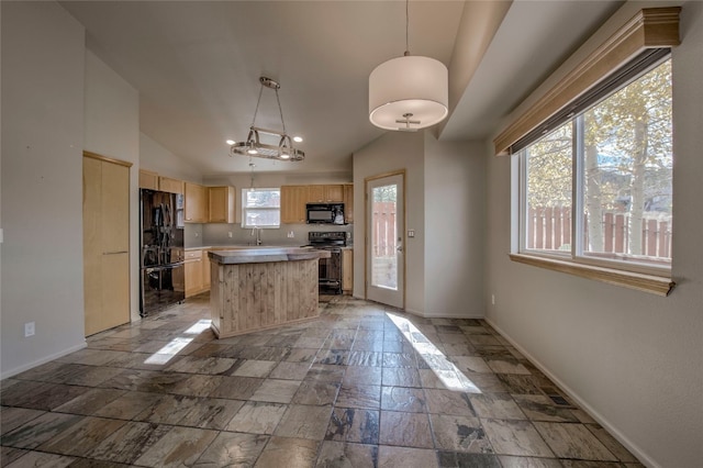 kitchen featuring a center island, vaulted ceiling, decorative light fixtures, light brown cabinetry, and black appliances