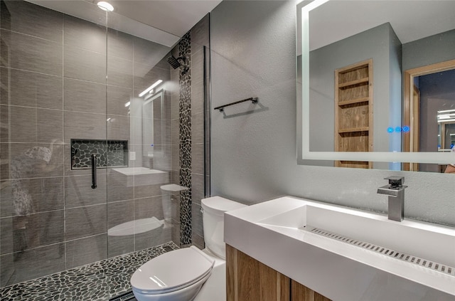 bathroom with vanity, toilet, and a shower with shower door