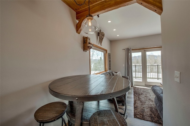 dining room with beam ceiling and light hardwood / wood-style floors