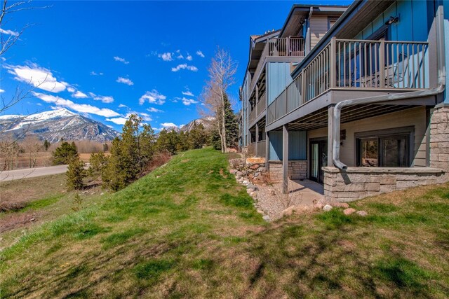 view of yard with a mountain view and a balcony