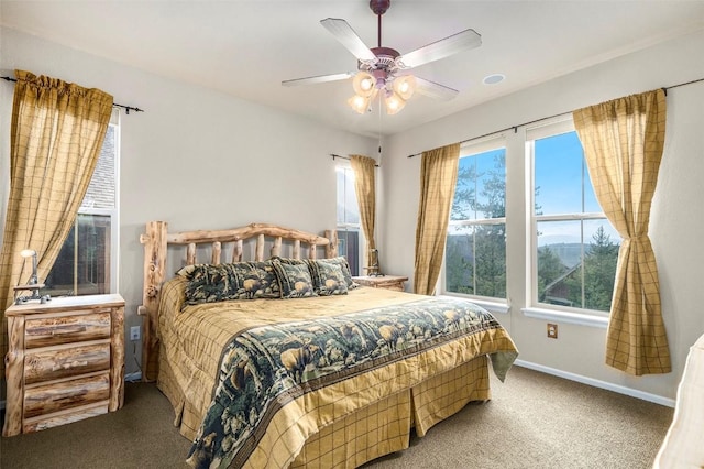 carpeted bedroom with multiple windows and ceiling fan