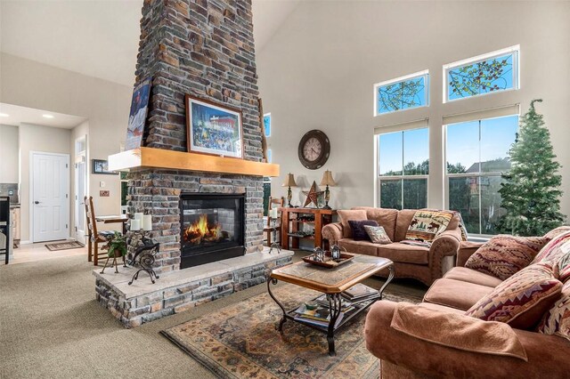 carpeted living room with a large fireplace and a high ceiling