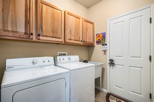 clothes washing area with cabinets and washer and clothes dryer