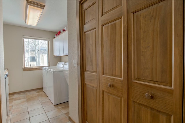 laundry room with light tile patterned floors, cabinet space, baseboards, and separate washer and dryer