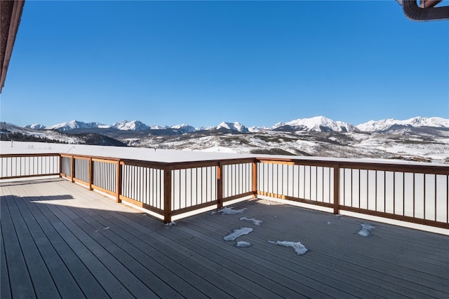 snow covered deck with a mountain view