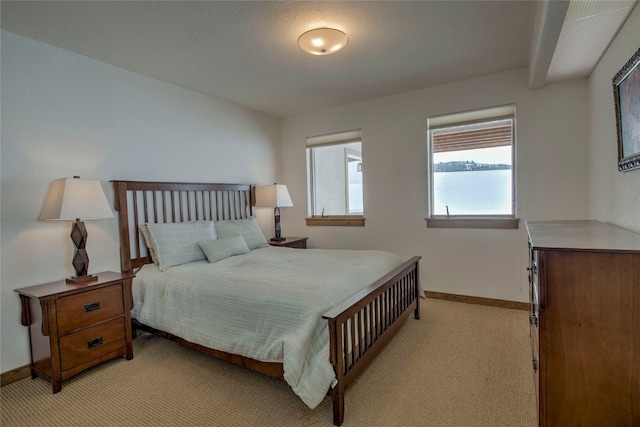 bedroom with baseboards and light colored carpet