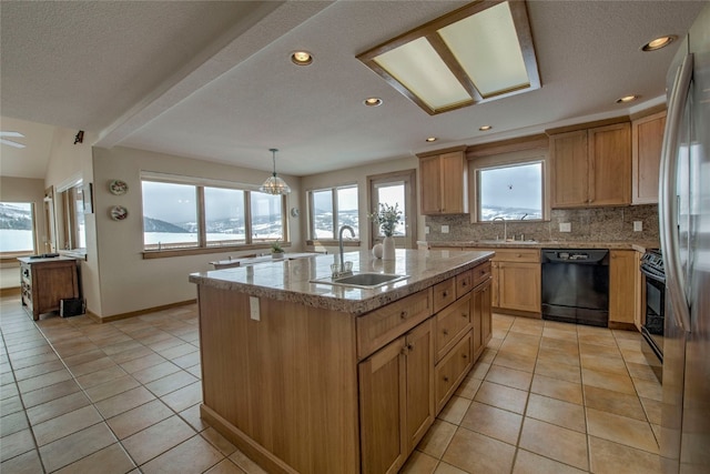 kitchen featuring light tile patterned floors, a kitchen island with sink, a sink, decorative backsplash, and black appliances