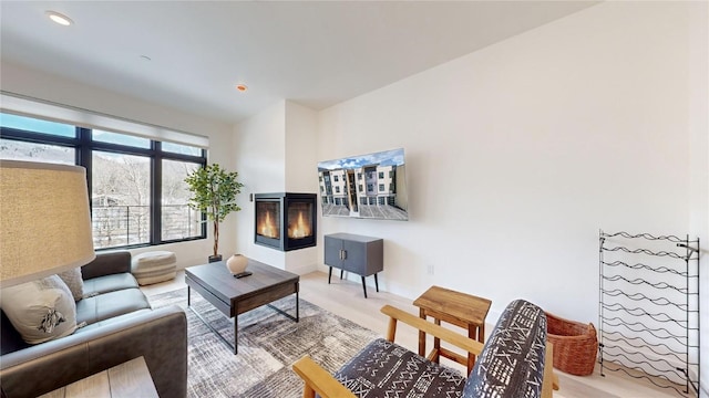 living area featuring a multi sided fireplace and recessed lighting