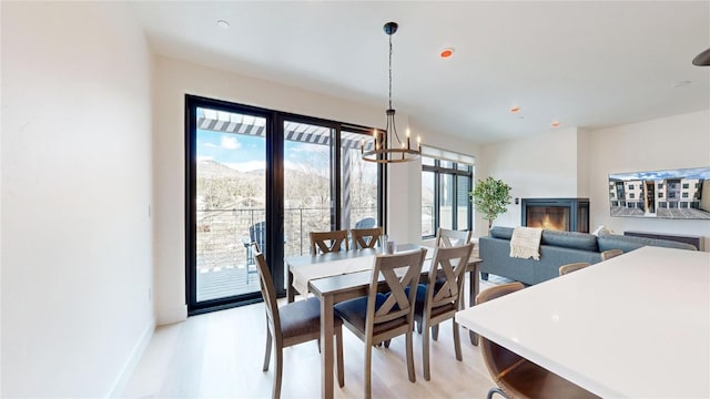 dining space with light wood-style floors, baseboards, and a notable chandelier