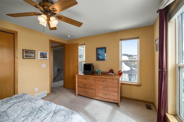 bedroom featuring baseboards, visible vents, and light colored carpet