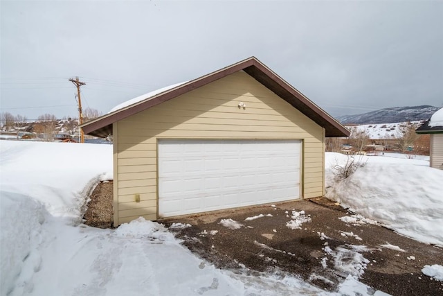 snow covered garage with a detached garage