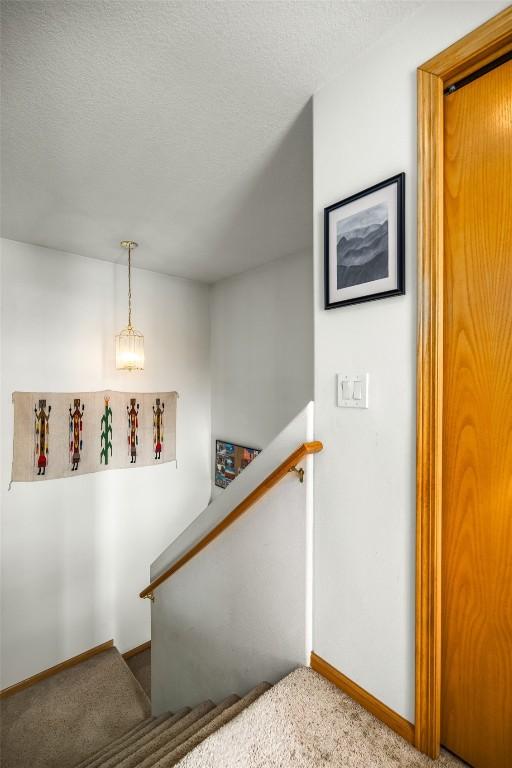 staircase featuring baseboards and a textured ceiling