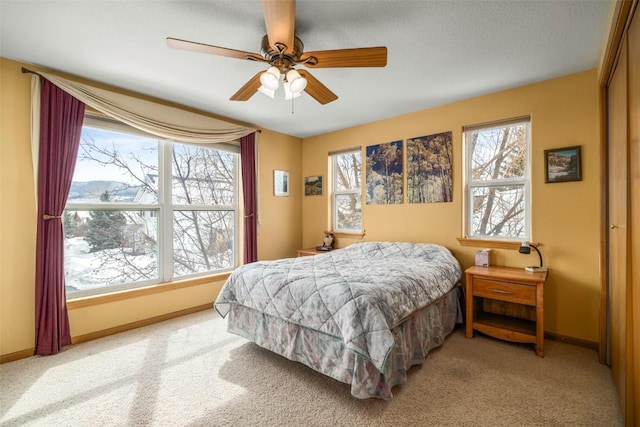 carpeted bedroom featuring ceiling fan and baseboards