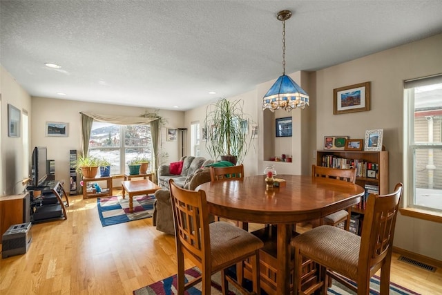 dining room featuring recessed lighting, visible vents, a textured ceiling, and light wood finished floors