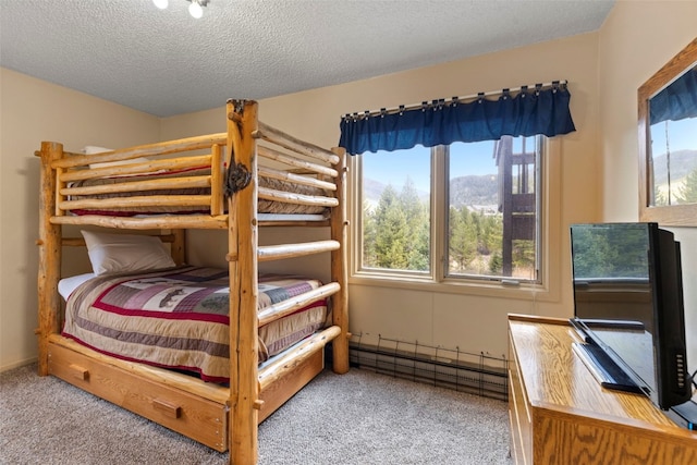 bedroom with light carpet, a baseboard heating unit, and a textured ceiling