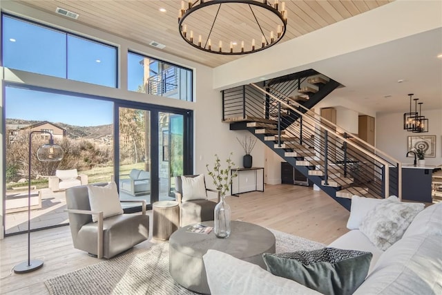 living room featuring an inviting chandelier, wooden ceiling, a mountain view, and hardwood / wood-style flooring