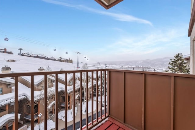 snow covered back of property with a mountain view