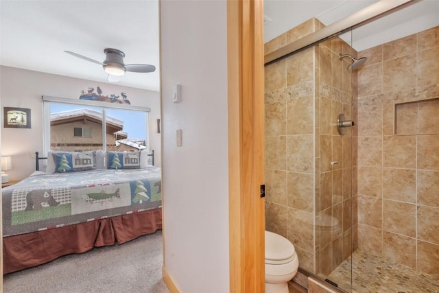 bathroom with ceiling fan, toilet, and a shower with shower door