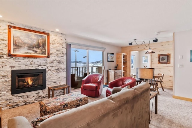 living room featuring a stone fireplace and light colored carpet