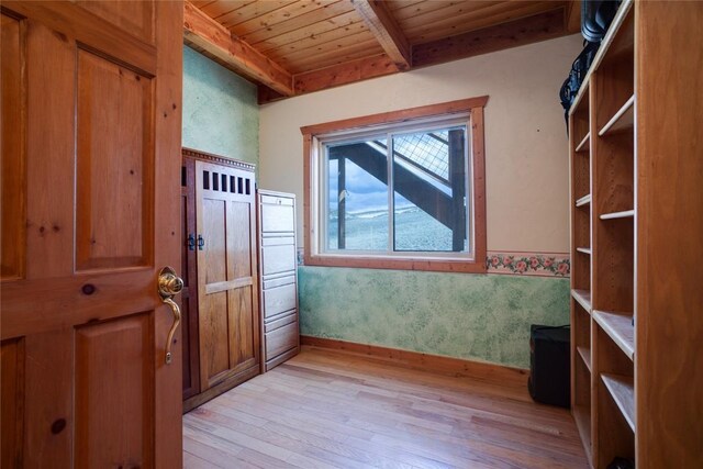 doorway to outside with beam ceiling, wood ceiling, and light hardwood / wood-style flooring