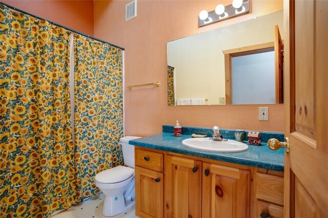 bathroom featuring a shower with shower curtain, vanity, and toilet