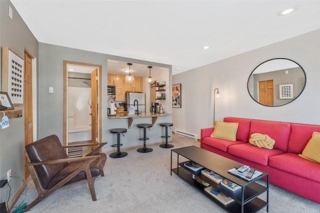 living room with a baseboard radiator, light colored carpet, baseboards, and recessed lighting