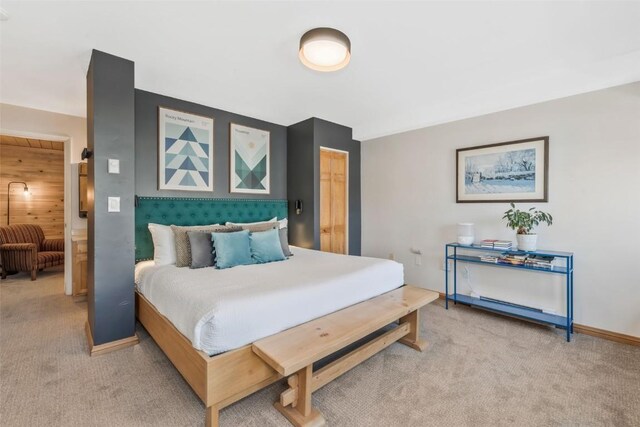 bedroom featuring light carpet and baseboards