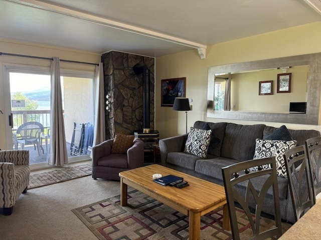 living room featuring beam ceiling, a wood stove, and carpet