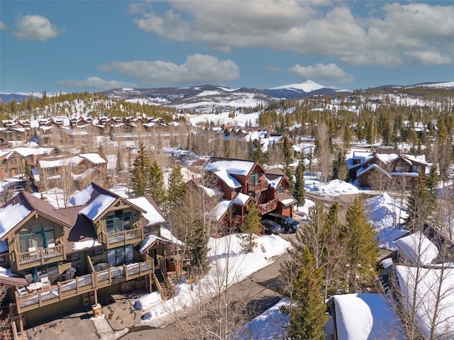 snowy aerial view featuring a residential view and a mountain view