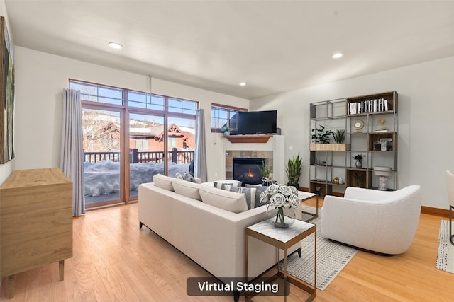 living area featuring light wood-style flooring, a fireplace, baseboards, and recessed lighting