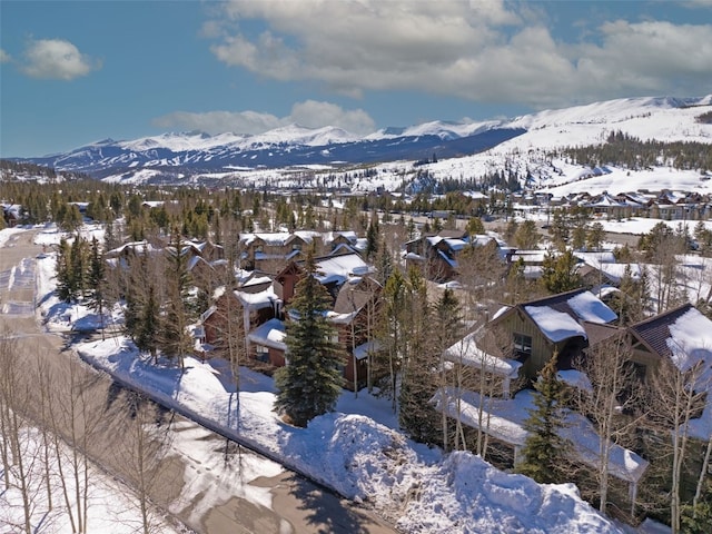 snowy aerial view featuring a residential view and a mountain view