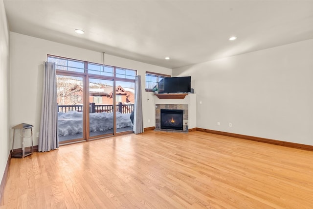 unfurnished living room featuring recessed lighting, a fireplace, light wood-style flooring, and baseboards