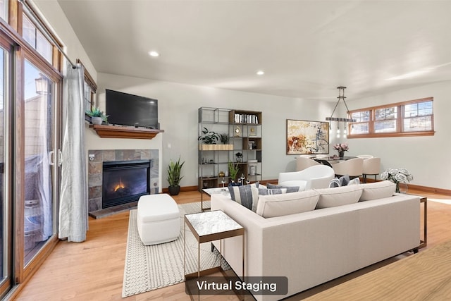 living area with light wood-type flooring, recessed lighting, baseboards, and a tile fireplace