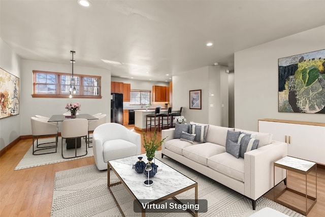 living room featuring light wood-type flooring, baseboards, and recessed lighting