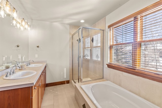 bathroom with a stall shower, tile patterned flooring, a sink, and baseboards