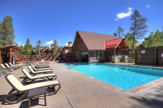 community pool with fence and a patio