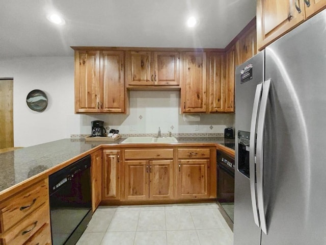 kitchen featuring black appliances, brown cabinetry, a sink, and light tile patterned flooring