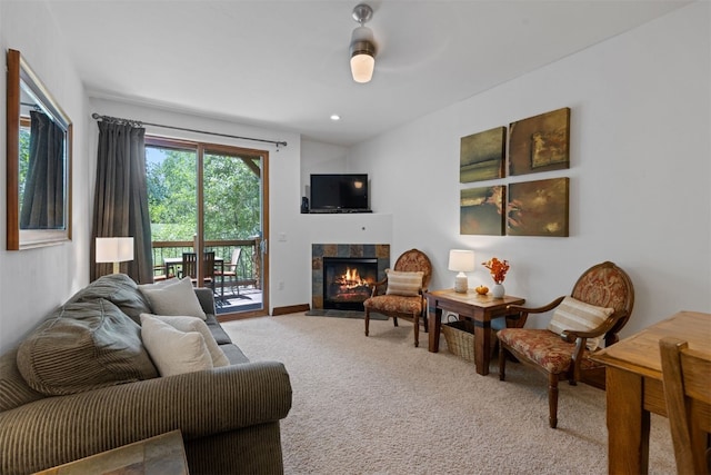 living room with ceiling fan, a fireplace, and light colored carpet