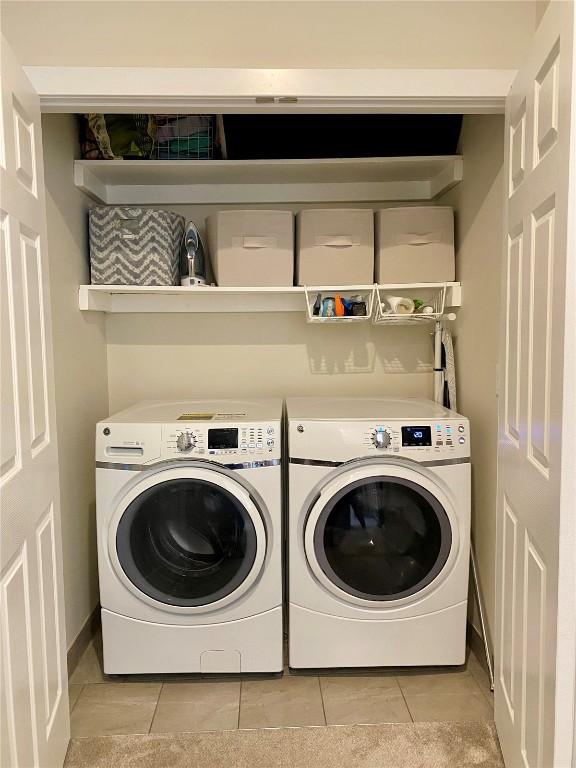 washroom featuring washer and dryer, laundry area, and light tile patterned floors