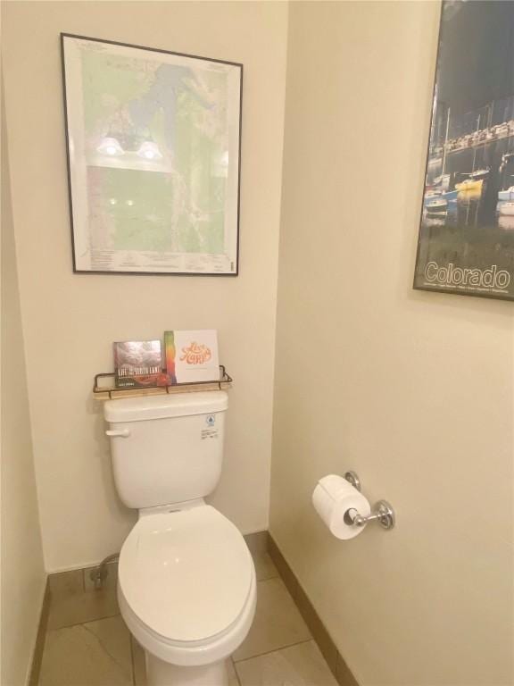 bathroom featuring tile patterned floors, baseboards, and toilet