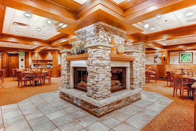 carpeted living room featuring a fireplace, decorative columns, beamed ceiling, coffered ceiling, and crown molding